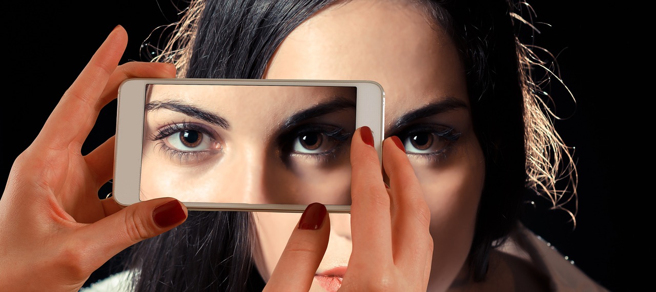 Smartphone als Lupe um Augen eines Gesichts besser zu erkennen